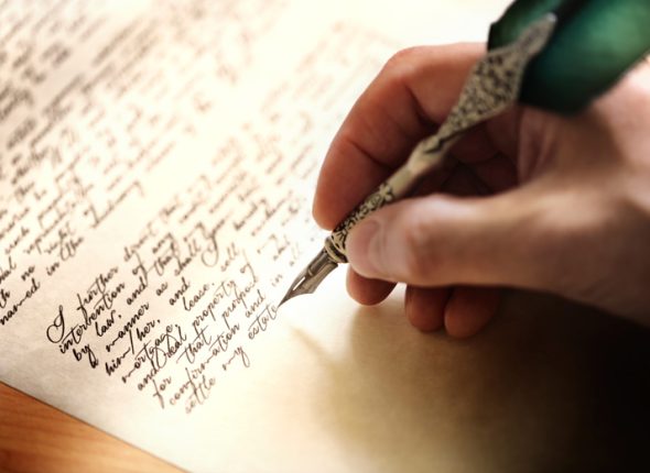 person-writing-letter-with-metal-quill
